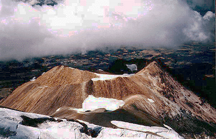 Shastina (12,330 feet, 3,759 m) from high on Shasta. Shastina is made up of mostly andesite flows and several dacite summit domes. Head of Whitney Glacier in foreground. View is to the northwest. Photo by R. Forrest Hopson.