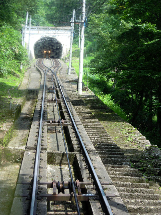 兩台纜車共用一組軌道, 用同一條纜線(在兩條軌道之間), 像翹翹板一樣輪流上下. 照片的上方有兩組軌道, 是會車的地方.