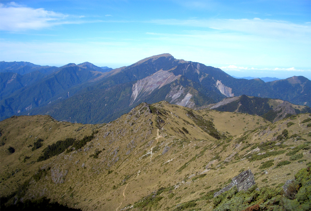 照片中間有關山(後)與鷹子嘴山(前)相疊, 兩者山形相似, 但一為草坡.一為岩坡.